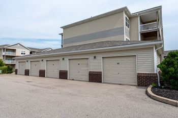 a garage with a row of white doors on the side of a house